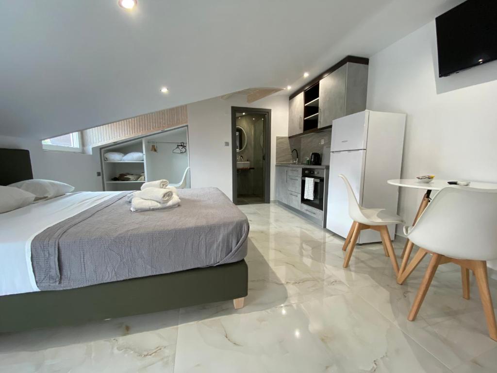 a bedroom with a bed and a table and a kitchen at Hotel Almira in Agia Triada