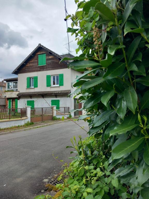 a house with green shutters on the side of the road at Au coteau des Thermes in Saint-Honoré-les-Bains