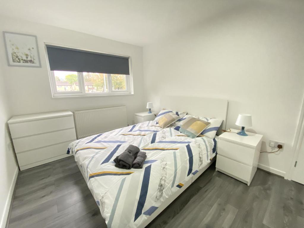 a white bedroom with a bed and a window at BEA Elcot Close in Manchester