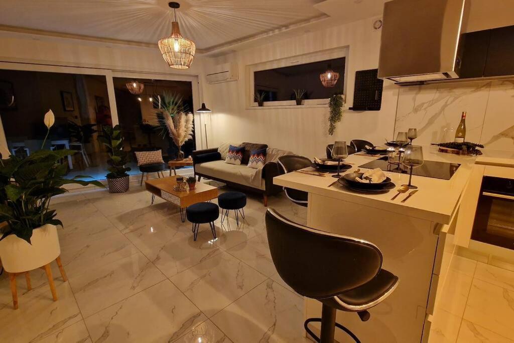 a kitchen and living room with a couch and a table at AOG PRESTIGE logement neuf avec SPA et écran de cinéma en rez de jardin in Colmar