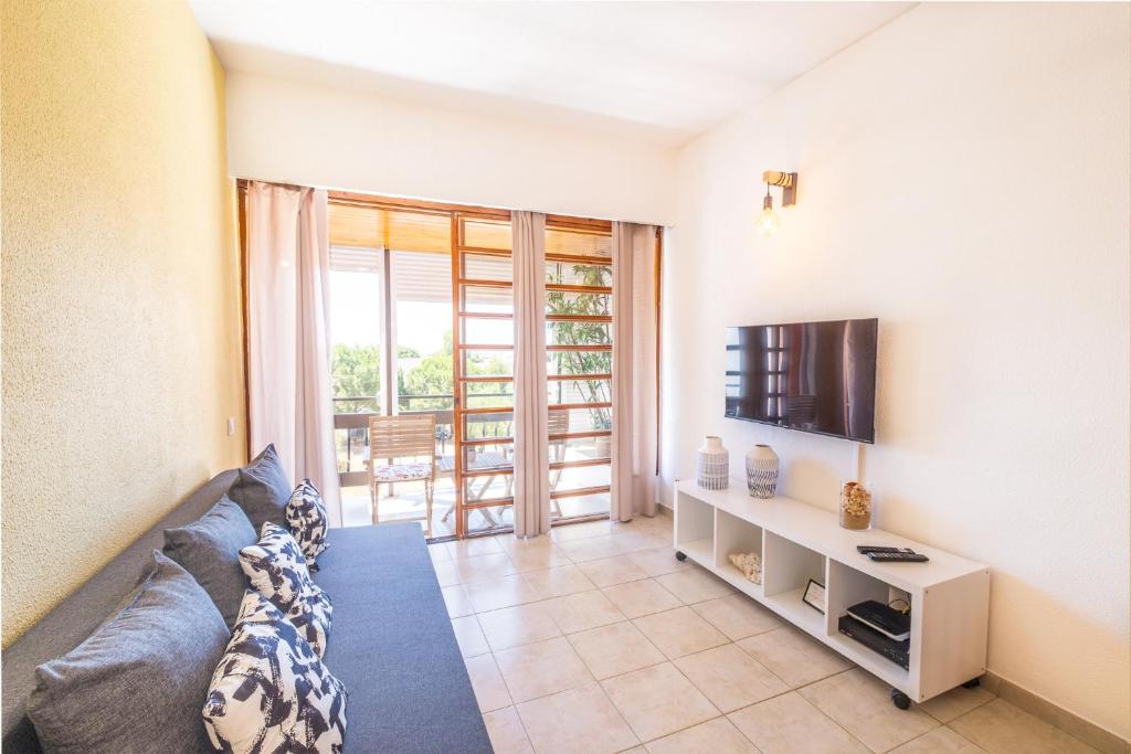 - un salon avec un canapé et une télévision dans l'établissement Entire Apartment 5min from Oura Beach, à Albufeira