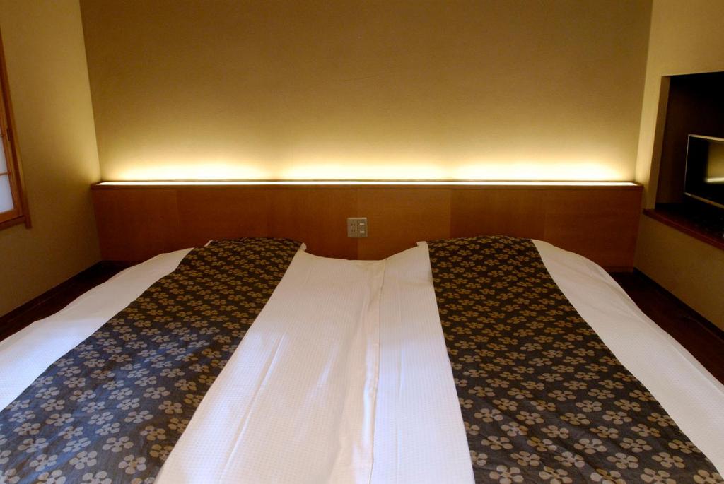 Postel nebo postele na pokoji v ubytování Ryokan Sumiya Kihoan