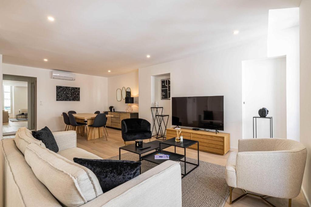 een woonkamer met een bank en een tv bij Superb 90m2 apartment in the heart of Cannes - rue d'Antibes in Cannes
