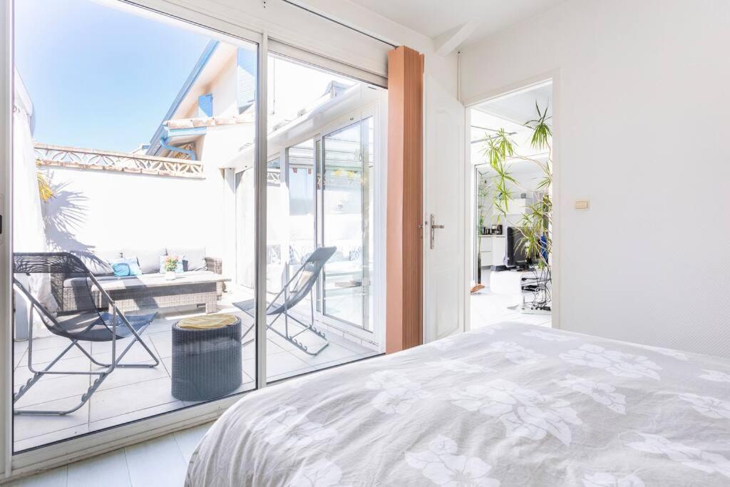 een slaapkamer met een bed en een groot raam bij Bassin Arcachon, Mais. 3 étoiles, spa, 500 m plage in Gujan-Mestras