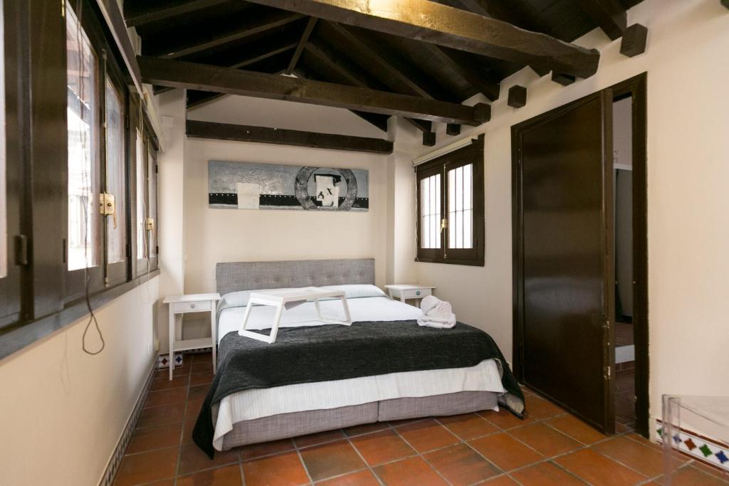 Un dormitorio con una cama en una habitación con ventanas. en Navitour Santa Ana, en Granada