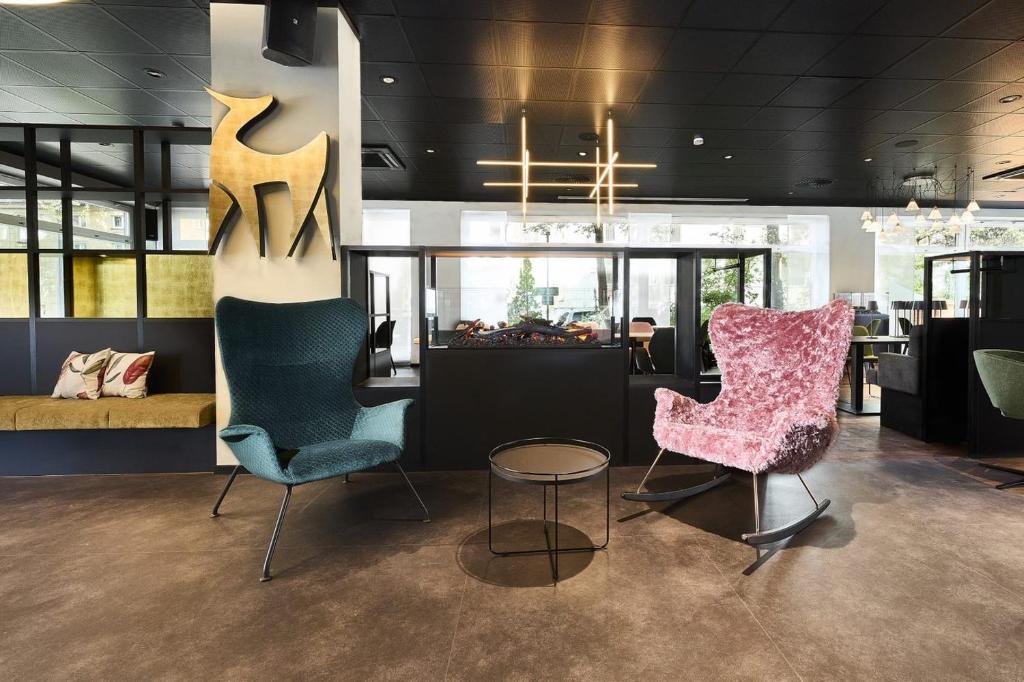 a room with two chairs and a table and a table at Hotel Rhönkitz in Bad Kissingen