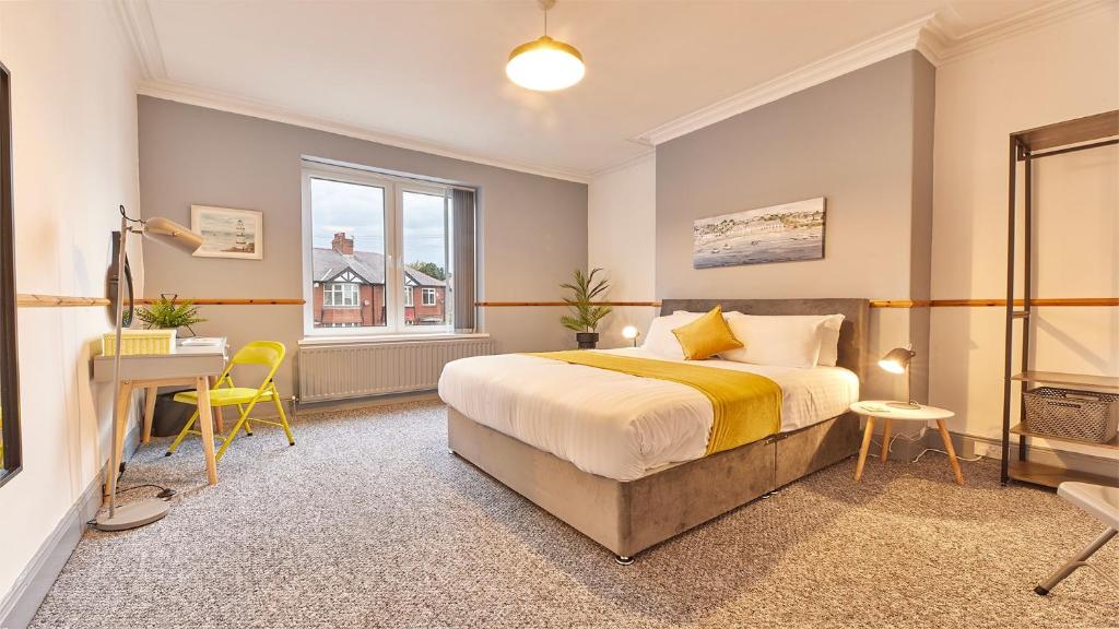 Bedlington的住宿－Host & Stay - Millbank Crescent Apartments，一间卧室配有一张床、一张书桌和一个窗户。
