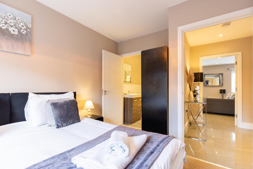 1 Schlafzimmer mit einem Bett und einem Bad in der Unterkunft Velvet 2-bedroom apartment, Conduit Lane, Hoddesdon in Hoddesdon
