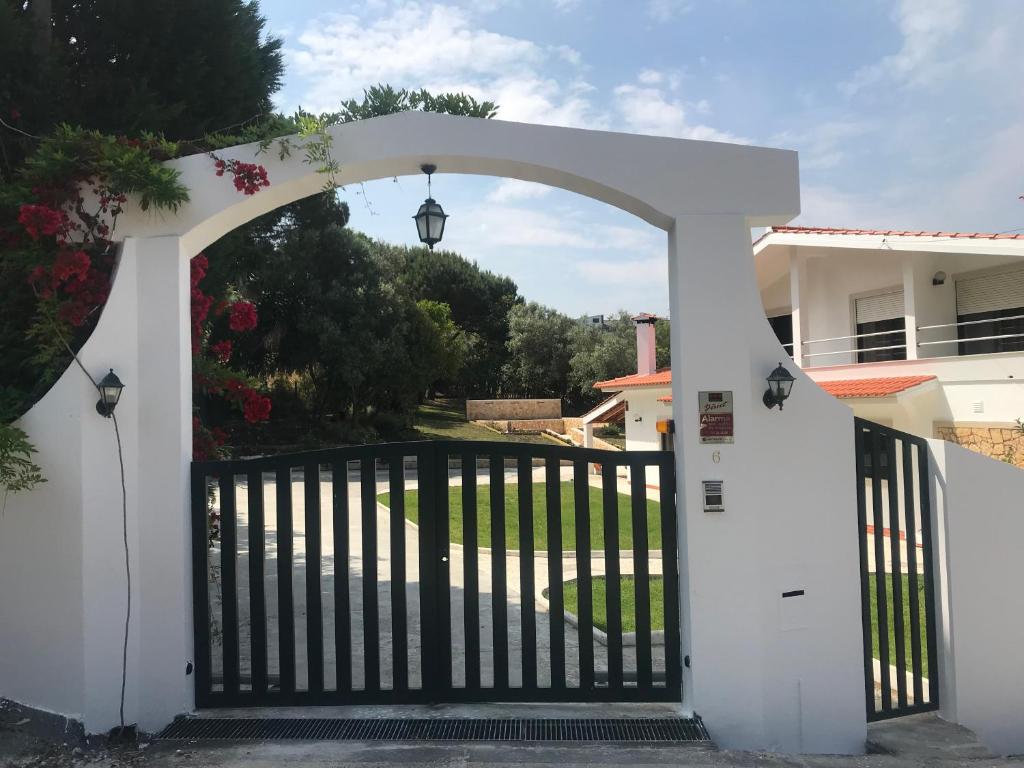 a white gate with an arch in a house at Farm stay in Maceira, Leiria 
