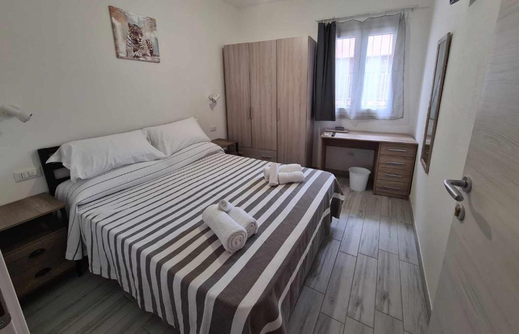 een slaapkamer met een bed met twee handdoeken erop bij Civico 14 Apartment 01 in Monserrato