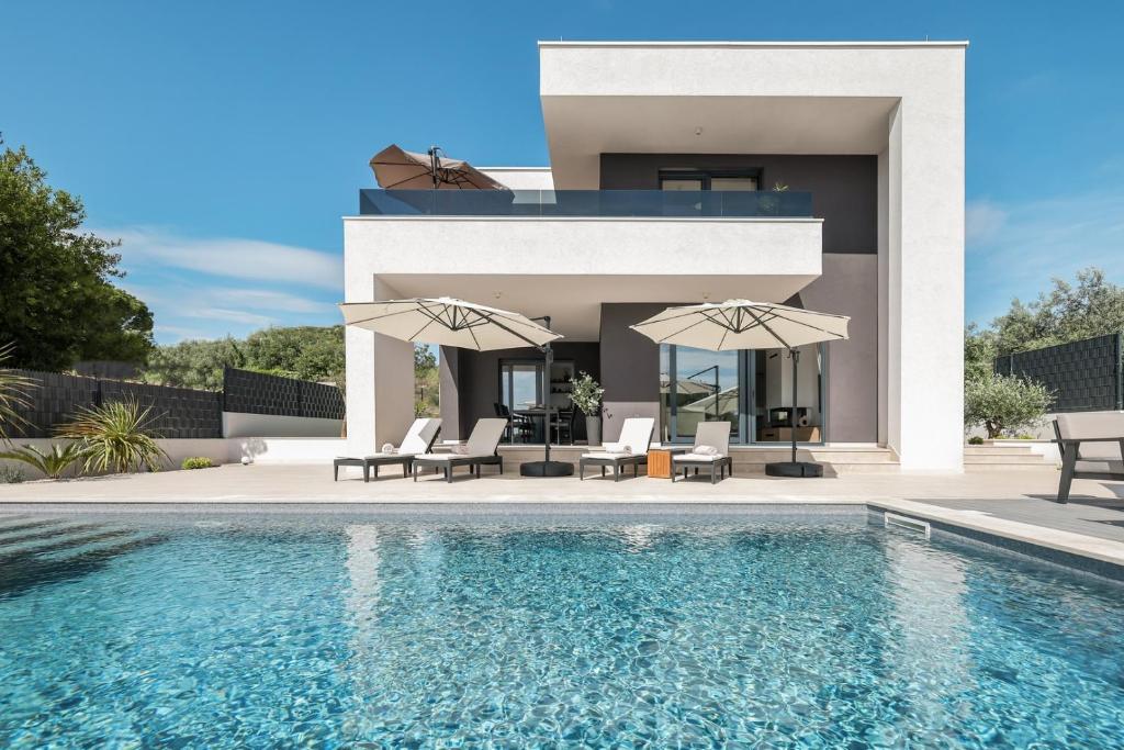 Villa con piscina y 2 sombrillas en Villa Dekorti - Adriatic Luxury Villas, en Kožino