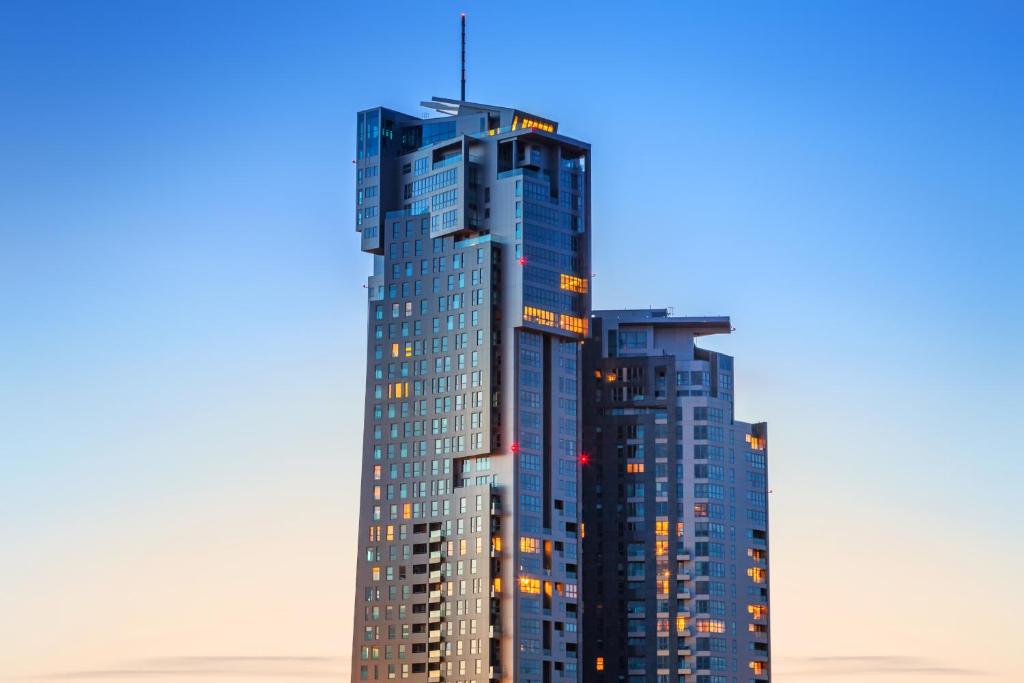 格地尼亞的住宿－豪華洛克菲勒海洋大廈公寓，一座高大的蓝色建筑,灯火通明