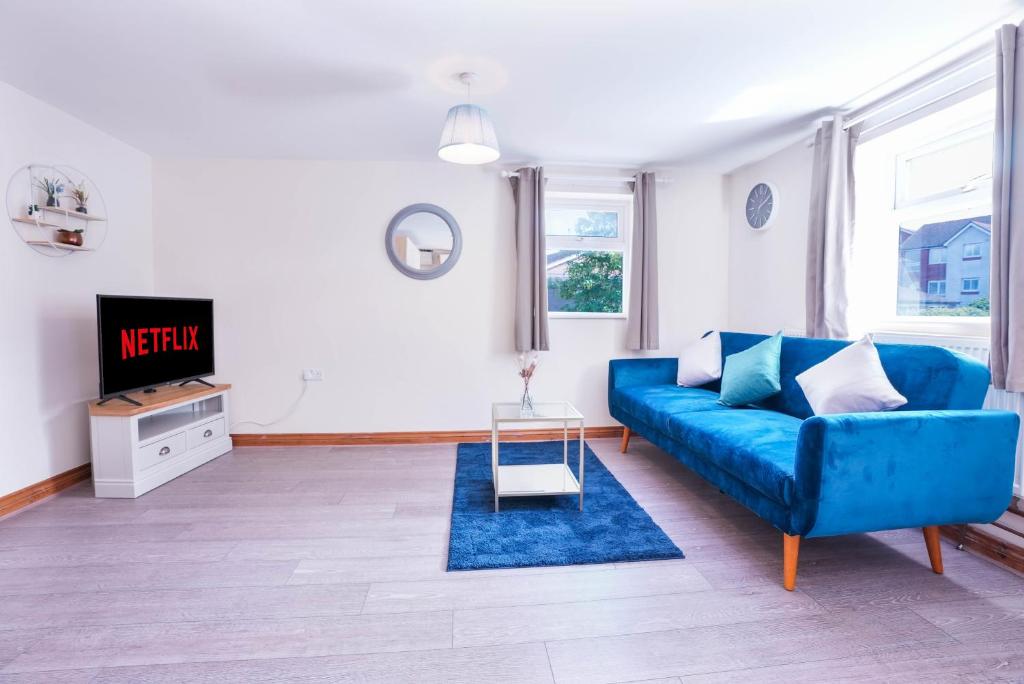un soggiorno con divano blu e TV di Beautiful 2 Bedroom,freeParking L Buzzard a Leighton Buzzard
