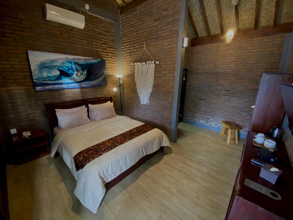 um quarto com uma cama e um quadro na parede em Kayon Griya Osing Villa - Ijen em Licin