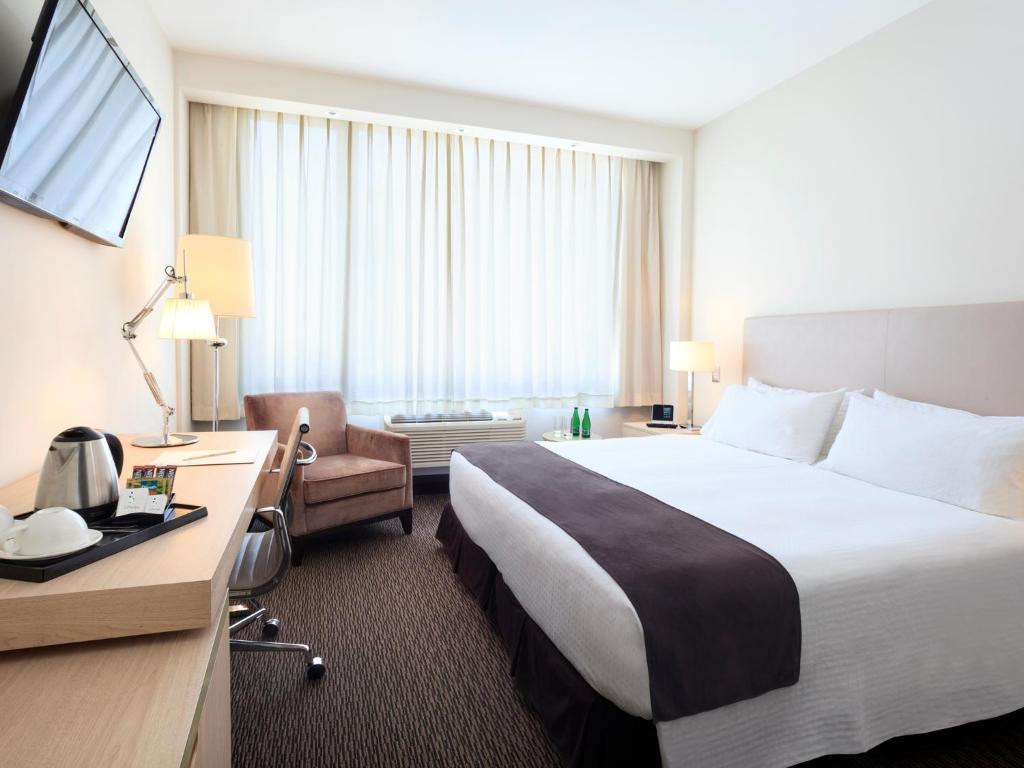ein Hotelzimmer mit einem großen Bett und einem Schreibtisch in der Unterkunft Spark Hoteles in Antofagasta