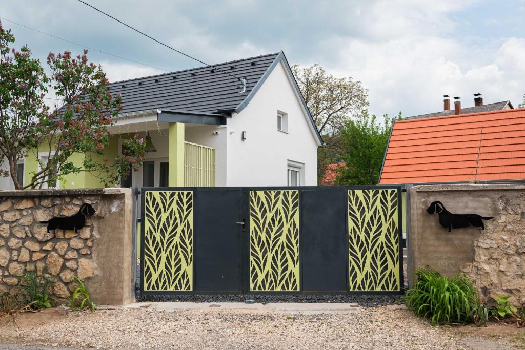 um portão preto e amarelo em frente a uma casa em Bökény-vendégház em Sümeg