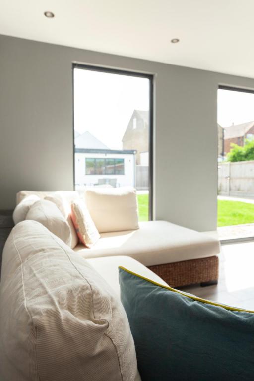 a living room with two couches and a large window at Sunbeam Cottage sleeps 10 in Whitstable