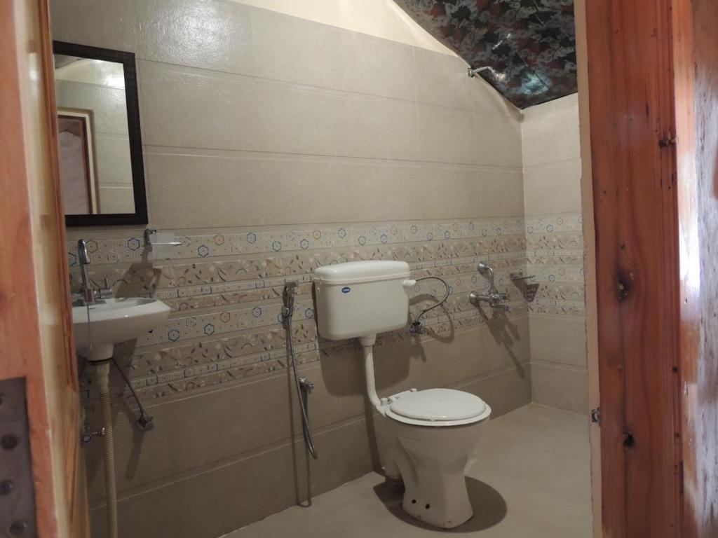 a bathroom with a toilet and a sink at Enthralling Escapes Nature Stay and Trek in Manāli