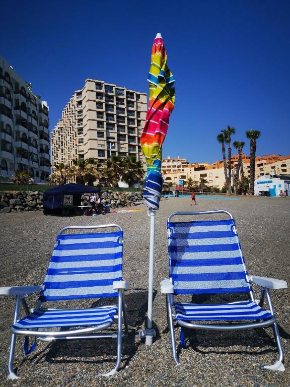 two beach chairs and a kite on a beach at VICO Estudio con parking in Almuñécar