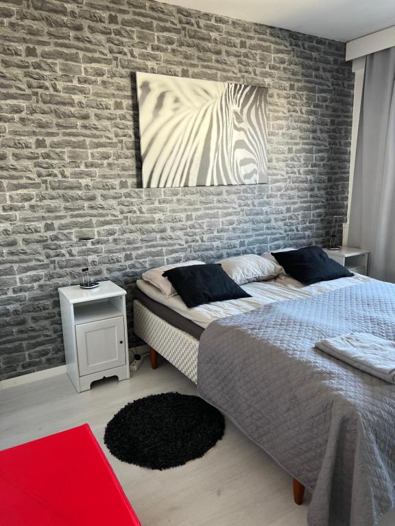 a bedroom with a bed and a brick wall at Kemi CITY l near snowcastle, 2 rooms, kitchen, glazed balcony, free parking on street in Kemi
