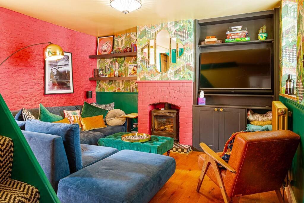 salon z kanapą i kominkiem w obiekcie Maple Rose - 2 Bed with Garden in Minchinhampton! w mieście Minchinhampton