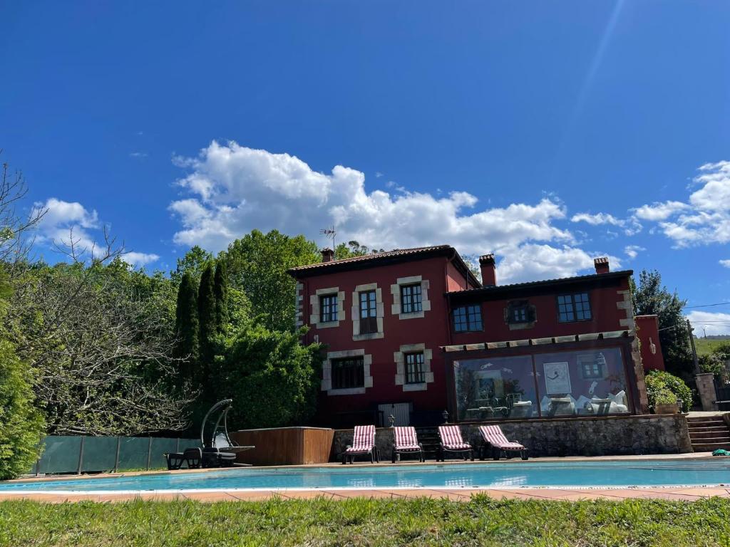 une maison avec une piscine en face de celle-ci dans l'établissement El palacio de Liaño pool chillout bbq, à Liaño