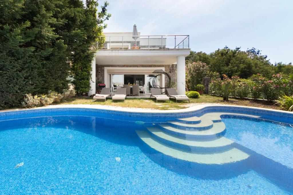 a swimming pool in front of a house at YALIKAVAK VILLA MAGNOLIA in Bodrum City