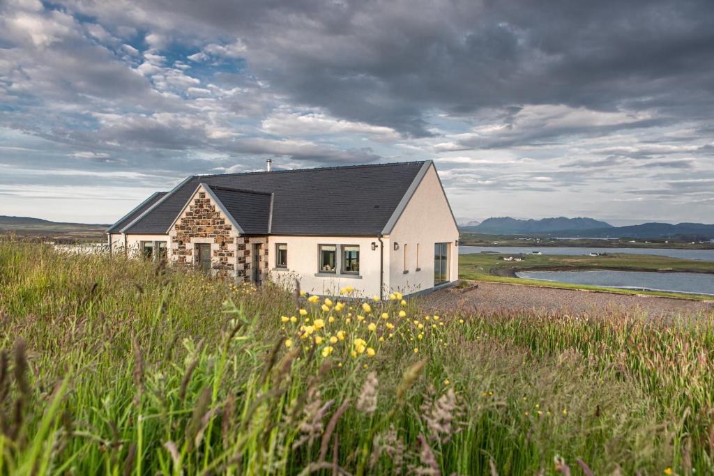 a house in the middle of a field with flowers at Captain’s Rest in Dunvegan