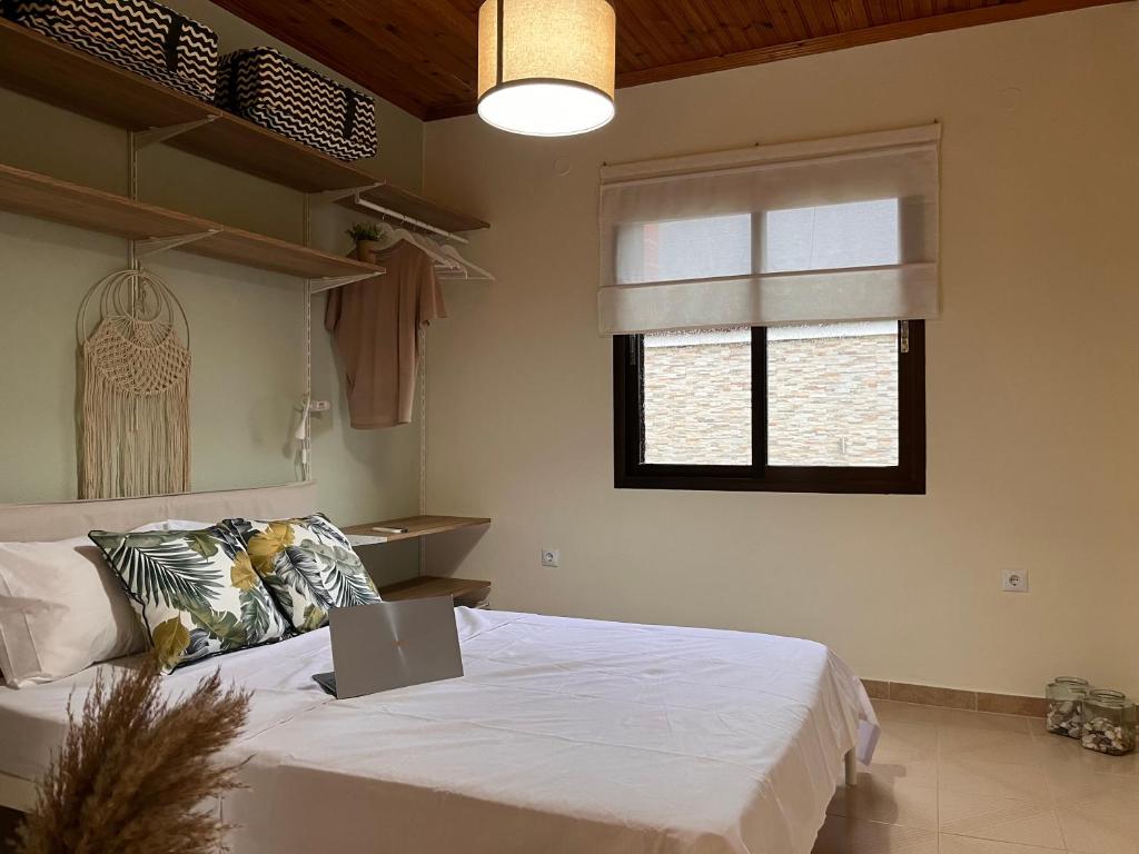 1 dormitorio con 1 cama con ordenador portátil en Niko Summer House, en Sozopoli