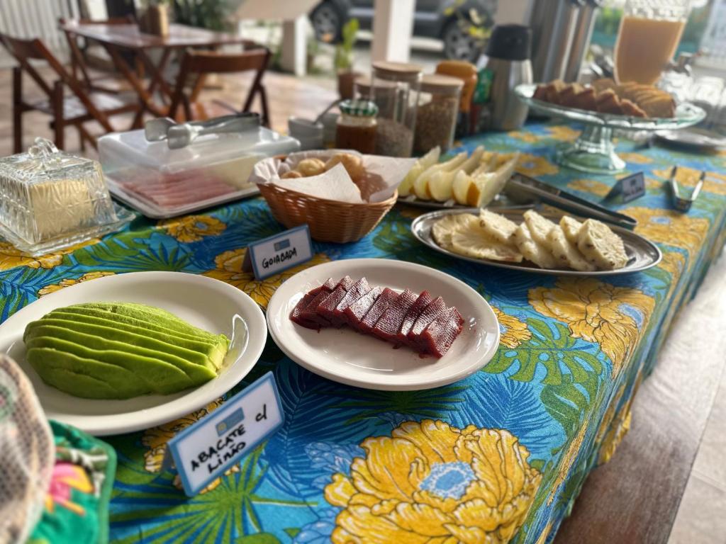 una mesa con platos de comida en un colorido mantel en Pousada Mawe en Paraty