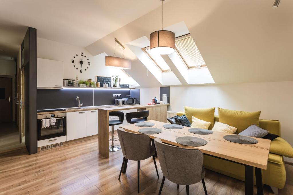 a kitchen and living room with a table and a couch at FLEXIHOME SK - Komenskeho - private parking spot - ultra modern and stylish in Košice