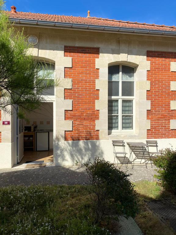 a building with two chairs sitting outside of it at Appartement familial centre et plage in Soulac-sur-Mer