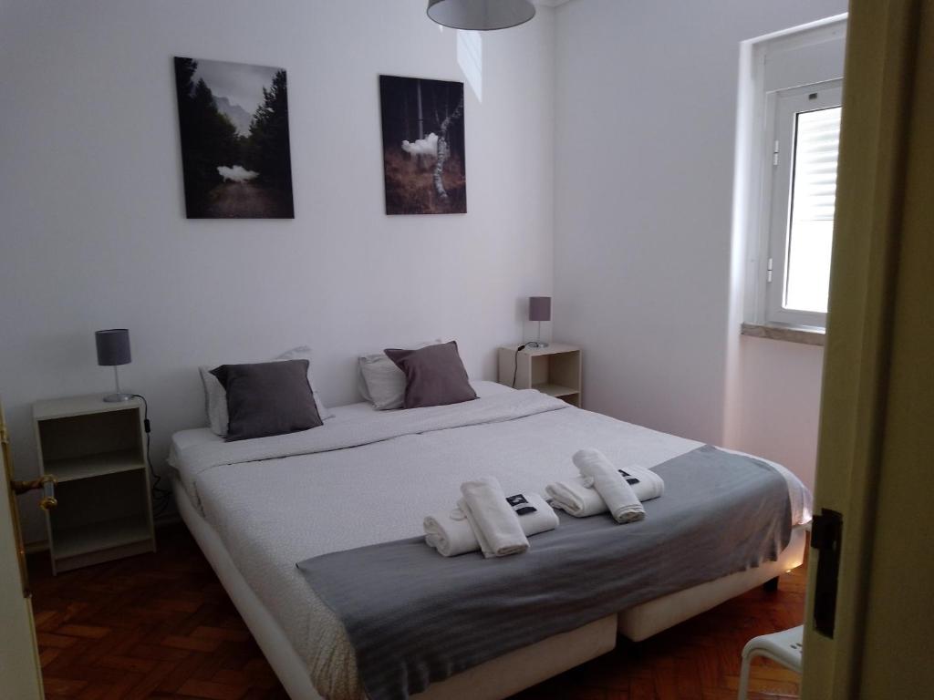 um quarto com uma cama com duas toalhas brancas em Oriente DNA Studios II em Lisboa