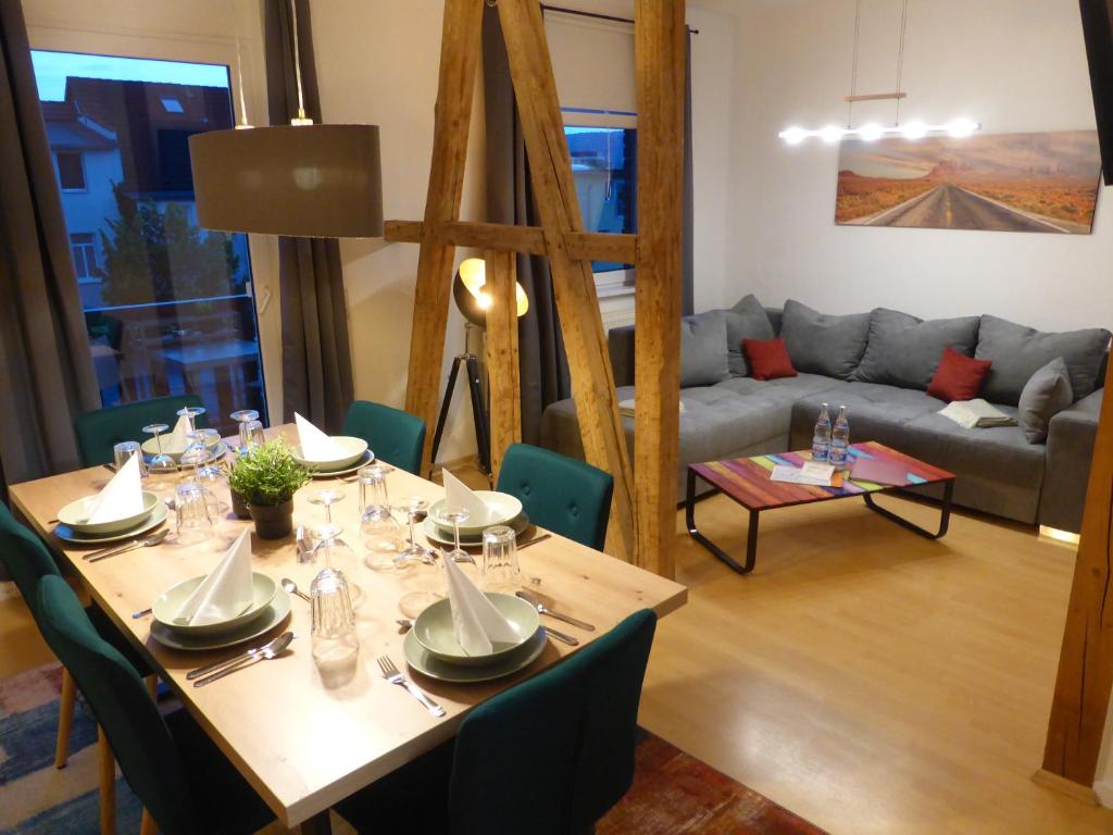 una sala da pranzo con tavolo e divano di Jena City Apartment, sonnig, kostenloses Parken & Wifi a Jena