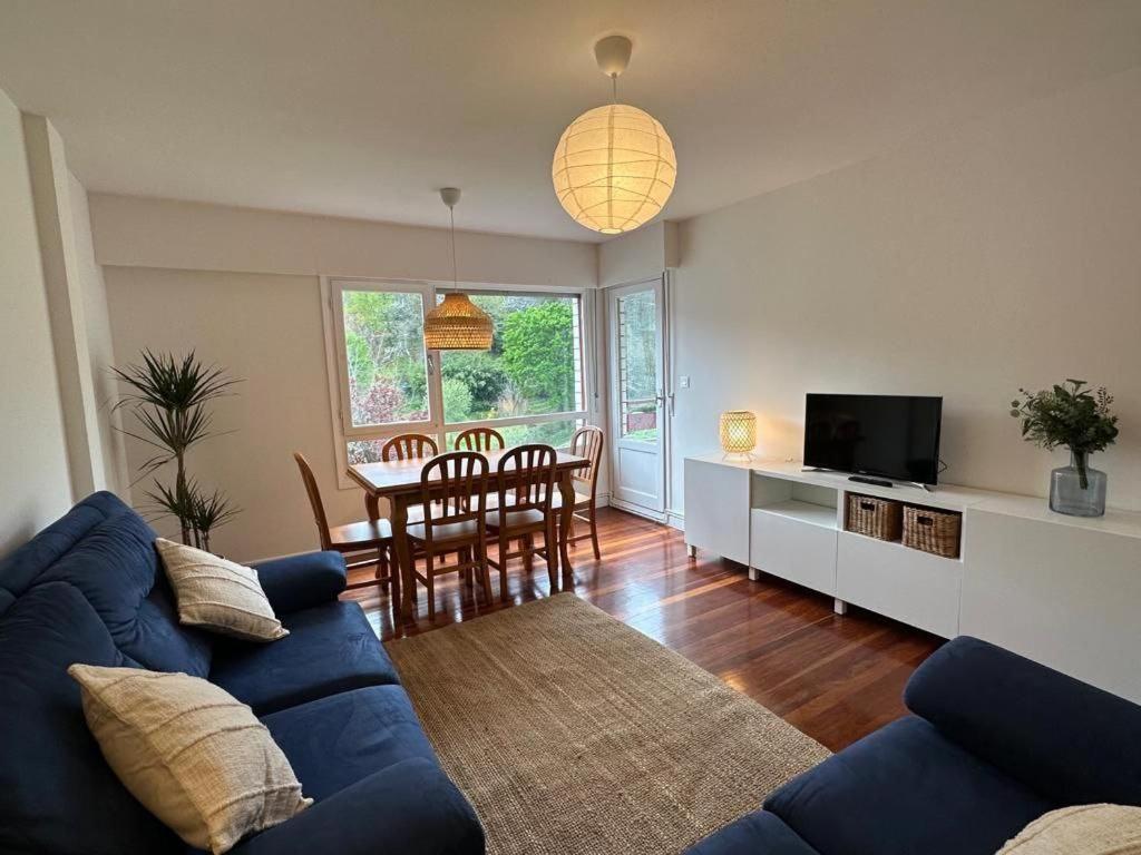 a living room with a blue couch and a table at SUKARRIETA Urdaibai in Pedernales