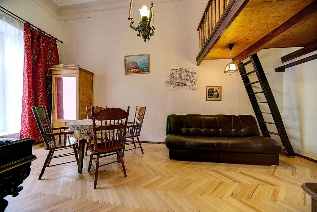 sala de estar con sofá, mesa y sillas en Apartment Bolshaya Morskaya, en San Petersburgo