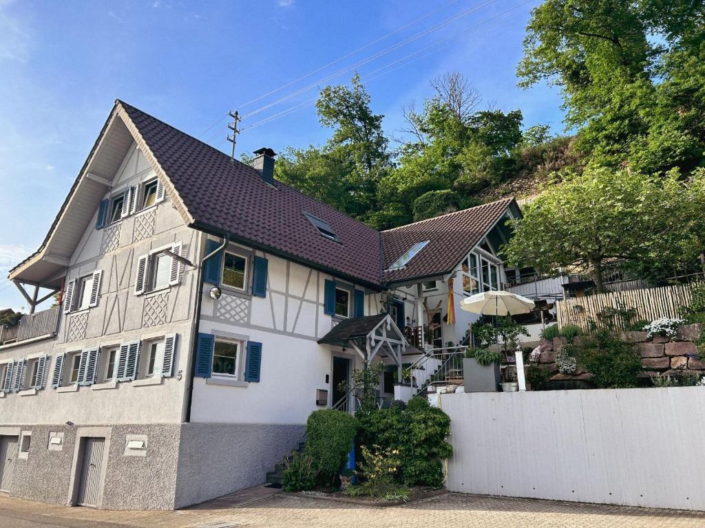 a white house with a black roof at Ferienwohnung Silvi und Heinz Huber in Durbach