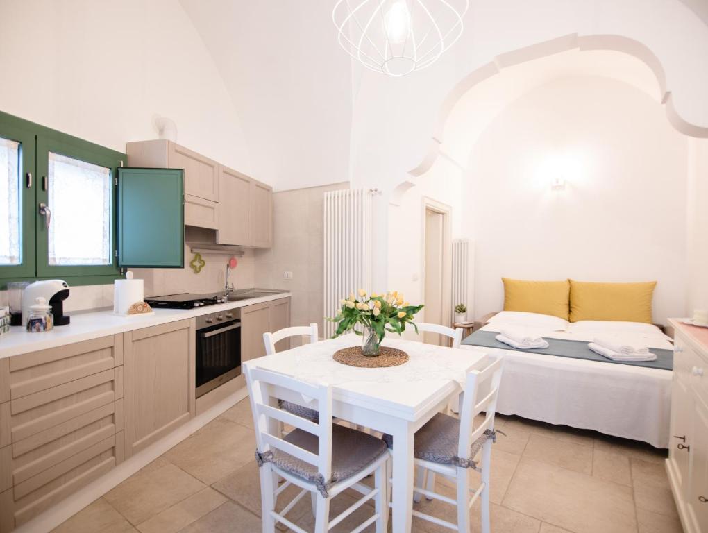 cocina con mesa y habitación con cama en Dimora Nonna Lina en San Michele Salentino