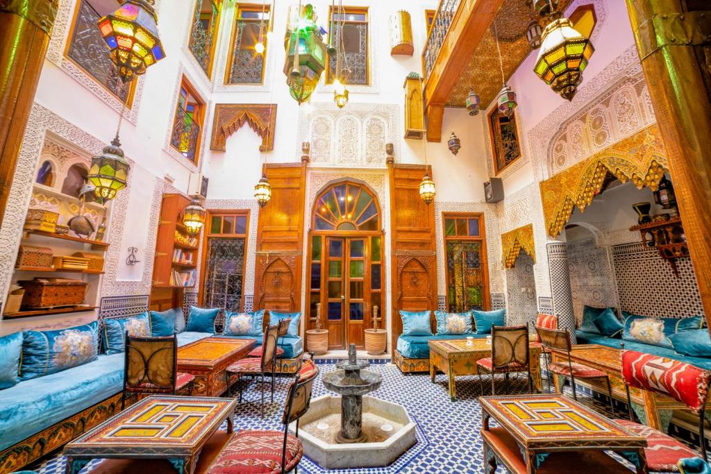 a living room with blue couches and tables at Riad Verus in Fez