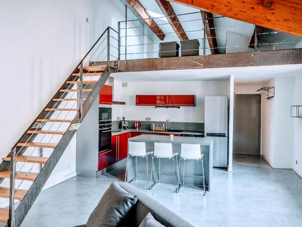 uma cozinha com armários vermelhos e uma escada em Loft Naturalia em Avignon