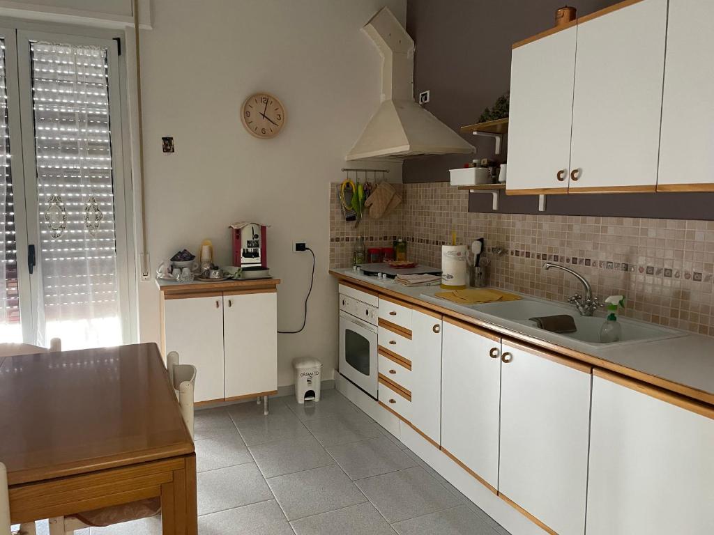 - une cuisine avec des placards blancs et un évier dans l'établissement De Nicolò Home, à Putignano