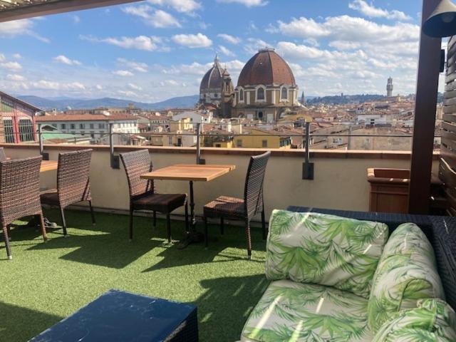 eine Couch auf einem Balkon mit Tisch und Stühlen in der Unterkunft Hotel Machiavelli Palace in Florenz