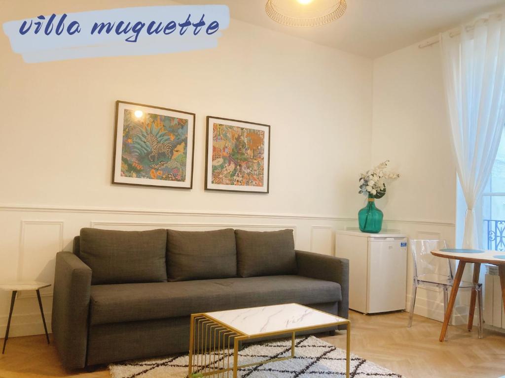 un salon avec un canapé et une table dans l'établissement Villa muguette - coeur de Vichy- RDC-véranda sur la terrasse, à Vichy