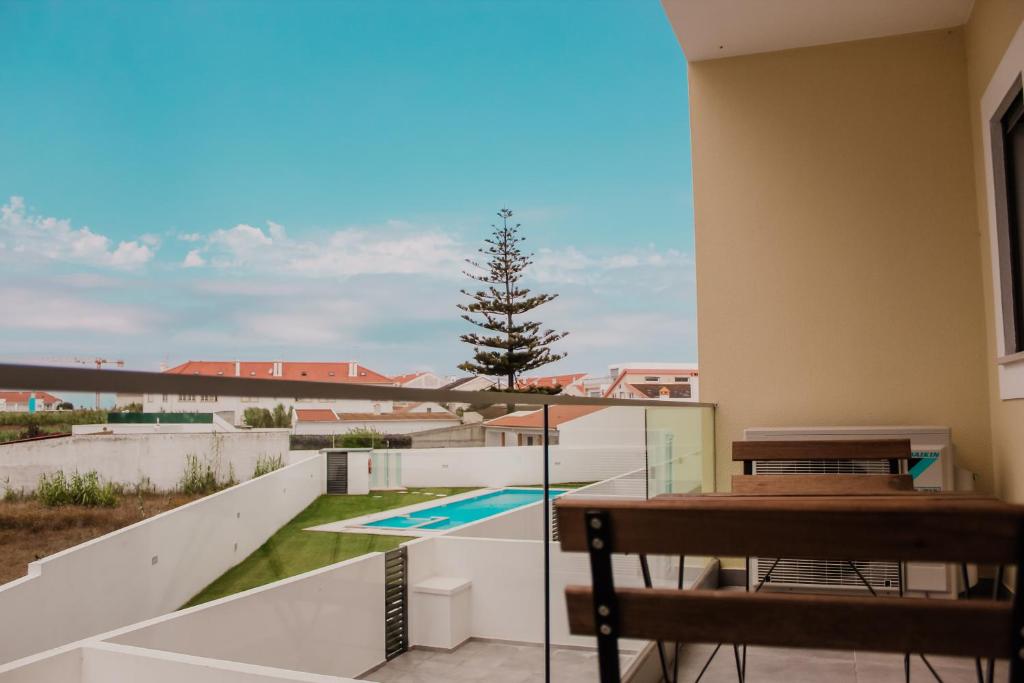 balcón con mesa y vistas a la piscina en Gold Apartment Baleal, en Ferrel