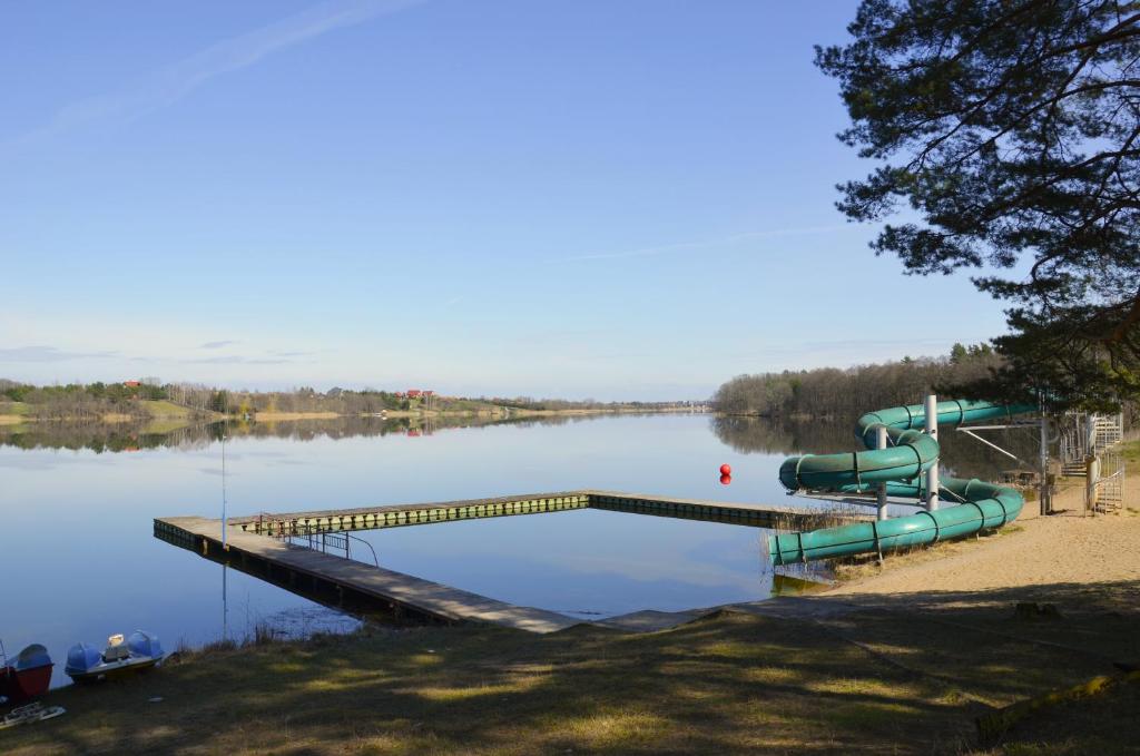 a dock with a water slide in the middle of a lake at Ośrodek Wypoczynkowy A26 - Mazury in Ełk