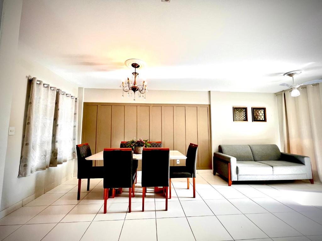 a dining room with a table and chairs and a couch at Hotel APART Zuccolotto 303 in Aracruz