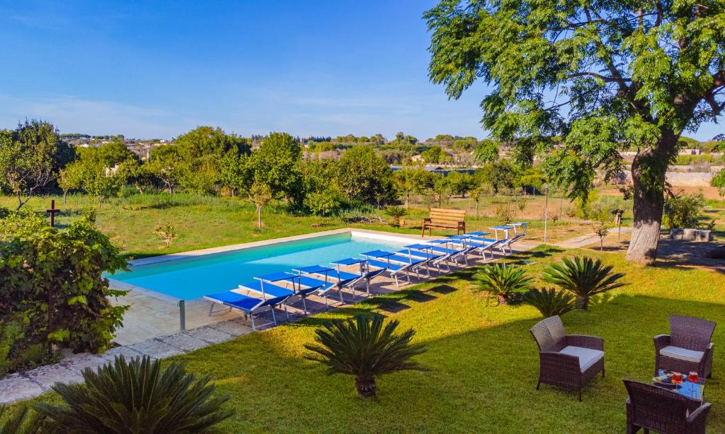 una piscina all'aperto con sedie a sdraio e una piscina di Villa Luritu Luxury Pool Tricase by HDSalento a Tricase