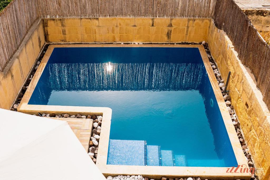 una piscina con una fuente de agua en una caja de madera en A charming Gozo Farmhouse in Sannat, en Sannat