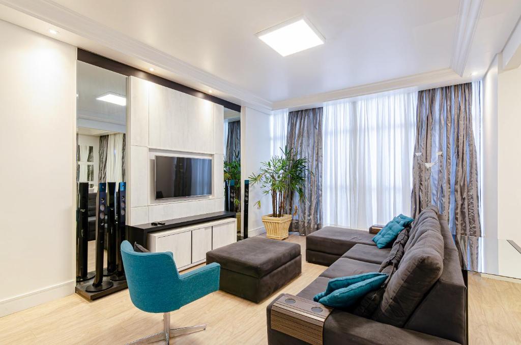 uma sala de estar com um sofá e uma televisão em Três Quartos, Gigante e confortável Próximo ao Hard Rock Café no Batel em Curitiba