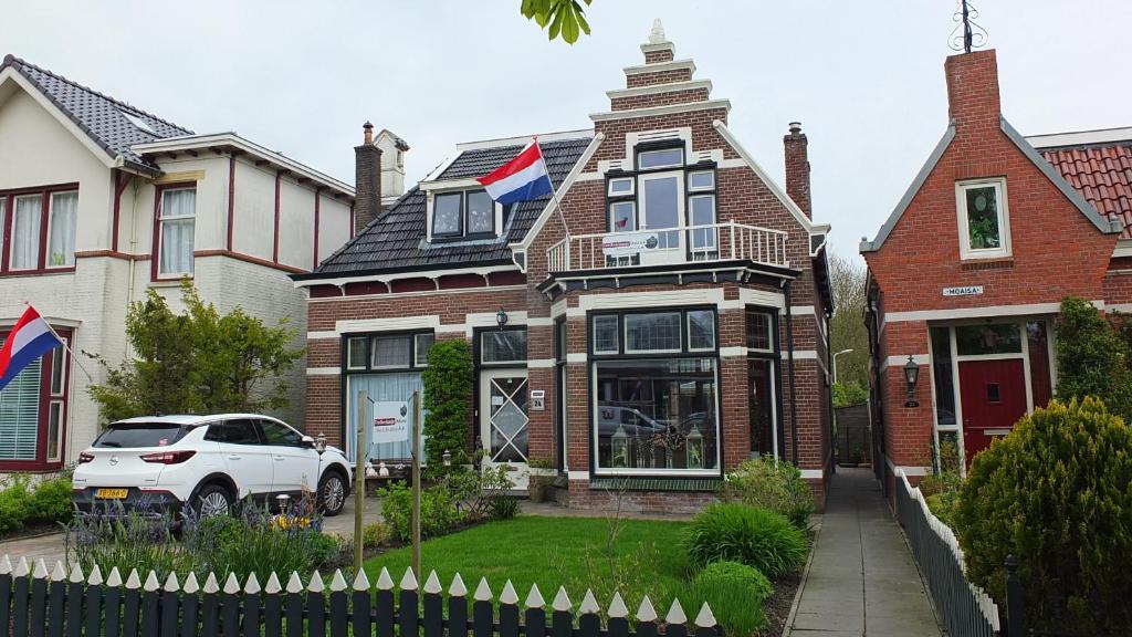 a white car parked in front of a house at B&B Ferdivedaasje in Dokkum